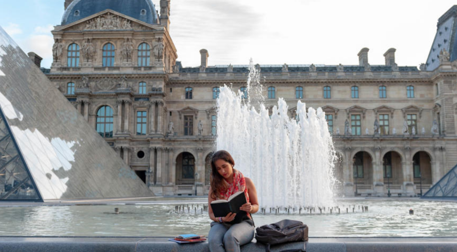 Girl reading near fountain