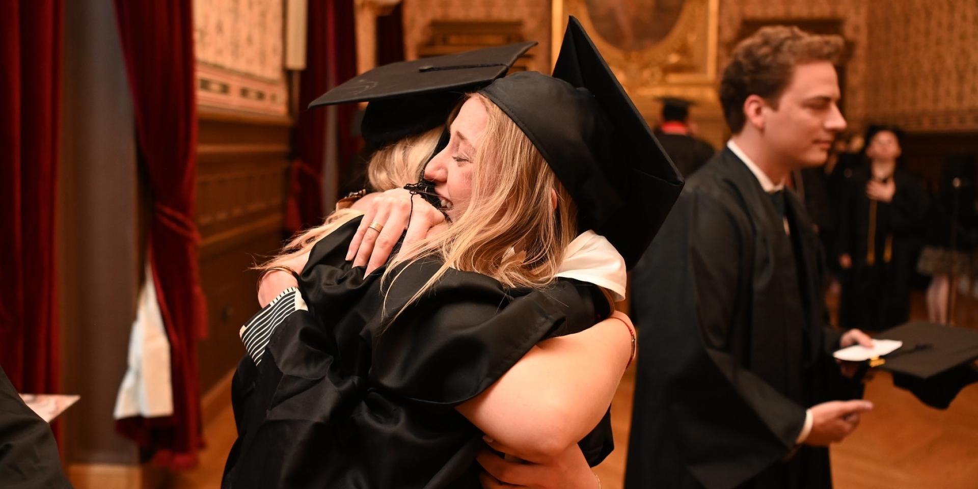 Graduates hug in celebration