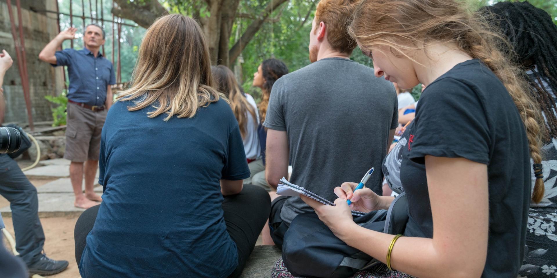 Student writing while on a trip to India